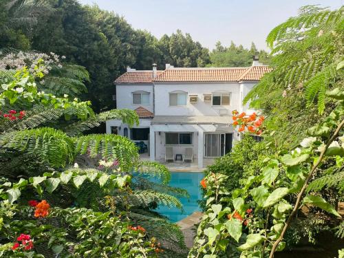 a house with a swimming pool in a garden at Villa by the Pyramids in Cairo