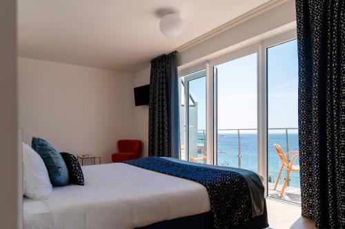 a bedroom with a bed with a view of the ocean at Les Sables Blancs in Concarneau