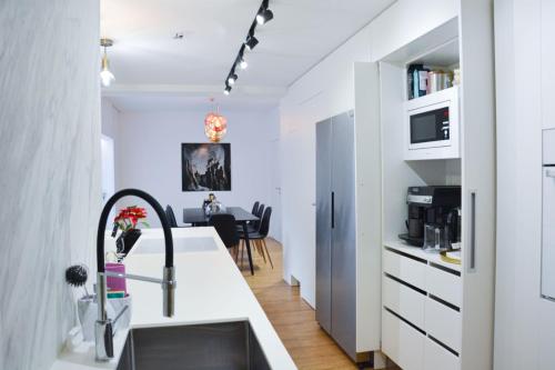 a white kitchen with a sink and a counter at Luxury apartment with private sauna Pod Javorovým in Třinec