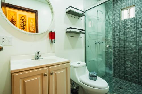 a bathroom with a toilet and a sink and a mirror at Hotel Revolución in Tijuana