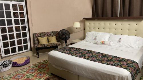 um quarto de hotel com uma cama e uma cadeira em La casa del colibrí em Campeche