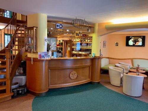 a bar in a store with a counter and chairs at Hotel Loucky in Litvínov