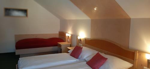 a small bedroom with two beds and a red bed at Landhotel-Restaurant Willingshofer in Gasen
