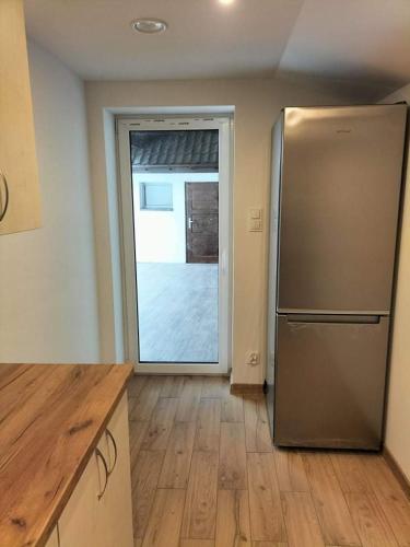 a kitchen with a stainless steel refrigerator next to a door at Zielony Zakątek in Złota