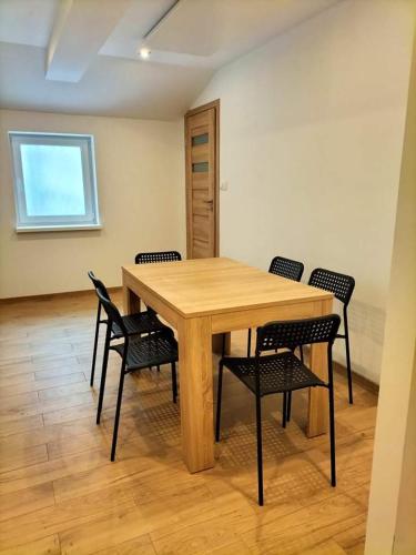 a wooden table and chairs in a room at Zielony Zakątek in Złota