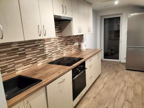 a kitchen with white cabinets and a wooden counter top at Zielony Zakątek in Złota