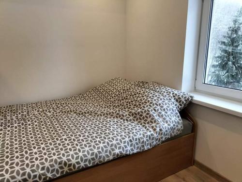 a bed sitting in a room next to a window at Zielony Zakątek in Złota