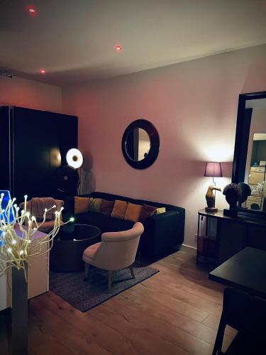 a living room with a couch and a chair at Suite Darcy & Spa in Dijon