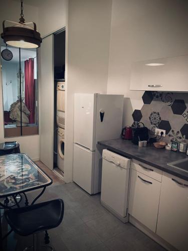 a kitchen with a white refrigerator and a table at Suite Darcy & Spa in Dijon
