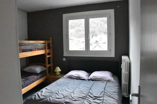 サン・ラリー・スランにあるLa montagne d'aureのベッドルーム1室(二段ベッド2台、窓付)が備わります。