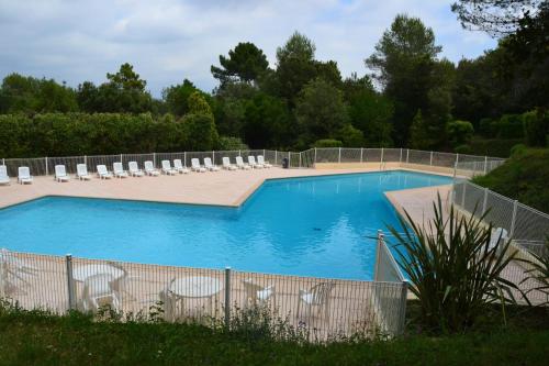 une piscine avec des chaises et une clôture dans l'établissement Villa Lucie, à Valbonne