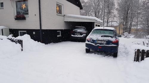 um carro estacionado numa entrada coberta de neve em Hassellyckan em Ulricehamn