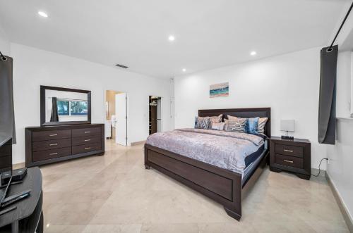 ein Schlafzimmer mit einem Bett, zwei Kommoden und einem TV in der Unterkunft Pool Villa in Miami