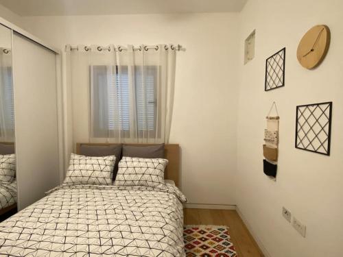 um pequeno quarto com uma cama e uma janela em Laura Compound- Authentic 1 BR charming & specious em Tel Aviv