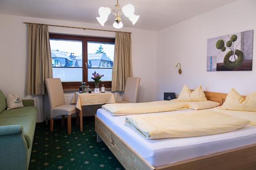 a hotel room with two beds and a table at Hotel-Restaurant Stefanihof in Fuschl am See