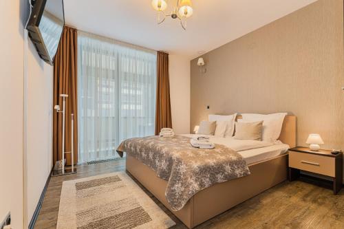 a bedroom with a bed and a large window at Sunset Silver Mountain in Poiana Brasov