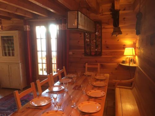 een eetkamer met een lange houten tafel in een hut bij Chalet Authentique MARIOUCHKA - 4 étoiles, avec Sauna, À 150M DES PISTES - Domaine Alpe d'Huez in Villard-Reculas