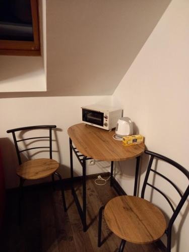 a small table with two chairs and a microwave on it at Pokój na Mazurach in Węgorzewo