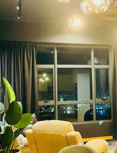 a living room with a yellow chair and a window at Serene Studio Imperium Residence Kuantan in Kuantan