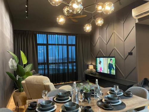 a living room with a table and a television at Serene Studio Imperium Residence Kuantan in Kuantan
