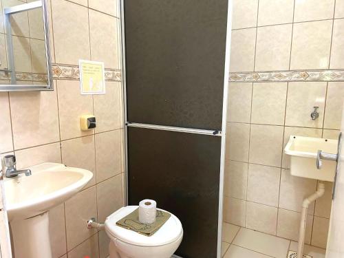 a small bathroom with a toilet and a sink at Pousada São Francisco in Florianópolis