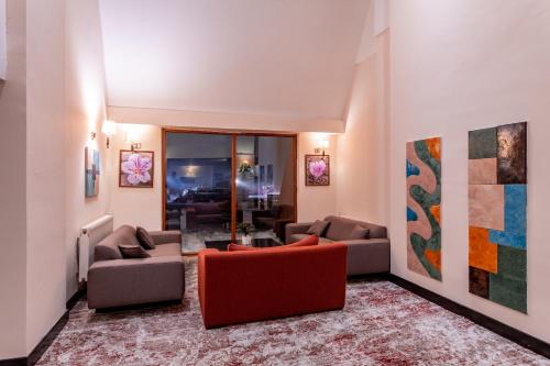 a living room with two couches and a red couch at Monte Baia Uludağ - Full Board Plus in Uludag