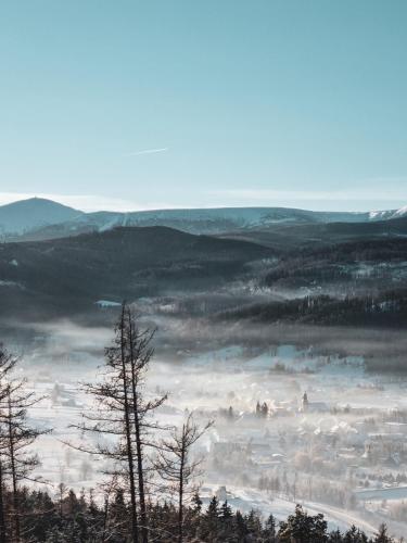 a view of a foggy valley with trees and buildings at Domek Drwala k. Karpacza in Sosnówka