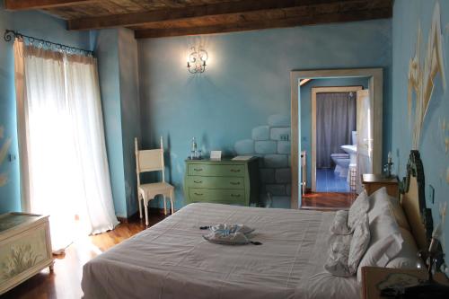 a bedroom with a large bed and a bathroom at Borgo Casale in Albareto