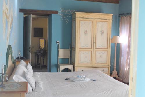 a bedroom with a white bed with a blue wall at Borgo Casale in Albareto