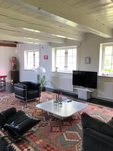 sala de estar con sofá y mesa en Monumental villa at the forest close to Haarlem and the beach, en Heemstede