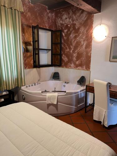 uma grande casa de banho com uma banheira e uma cama em TENUTA VALMINIER em Villanova dʼAsti