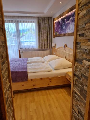 a bedroom with a bed and a brick wall at Edelsteinhotel Guniwirt in Krakaudorf
