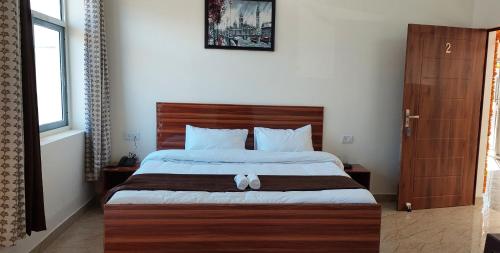 una camera con un grande letto con testiera in legno di Shivalik Riverine Homestay and hotel a Lansdowne