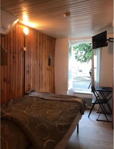 une chambre avec un lit, une télévision et une fenêtre dans l'établissement Studio hypercentre à 2 pas de la gare Appt n°1, à Agen