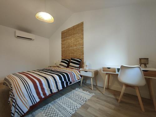 a bedroom with a bed and a desk and a chair at Bon encontre, Allée de la vierge in Bon-Encontre