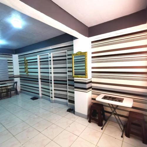 una habitación con rayas en las paredes y una mesa en Cabantuan City PNY TRANSIENT INN 5, en Cabanatúan