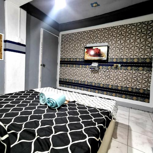 1 dormitorio con pared estampada en blanco y negro en Cabantuan City PNY TRANSIENT INN 5, en Cabanatúan