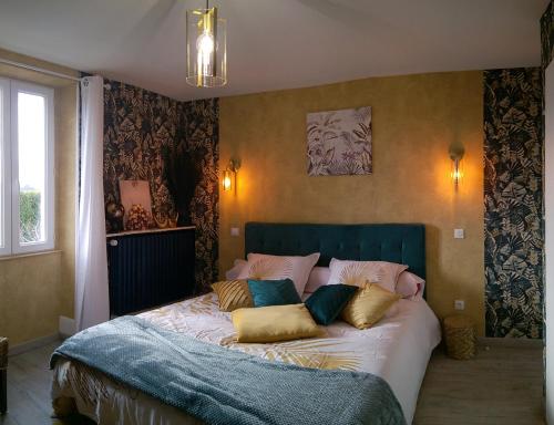 Un dormitorio con una cama grande con almohadas. en La Clé Des Champs en Chabeuil