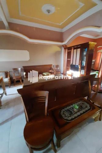 a piano and a chair in a living room at Bromo Indah Lestari Homestay Mitra RedDoorz in Pasuruan
