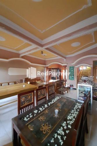 a large dining room with a table and chairs at Bromo Indah Lestari Homestay Mitra RedDoorz in Pasuruan