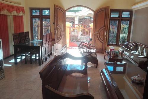 a living room with a couch and a table and chairs at Bromo Indah Lestari Homestay Mitra RedDoorz in Pasuruan