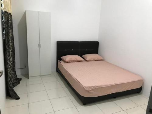 a bedroom with a bed with pink pillows on it at An-Nur Homestay in Sungai Petani