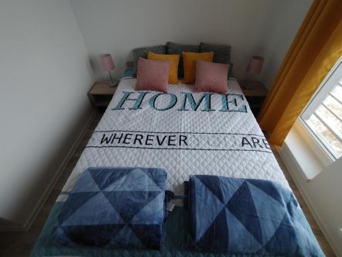 a bedroom with a bed with the words home where never are at Apartament Rumia Trójmiasto Kaszuby in Rumia
