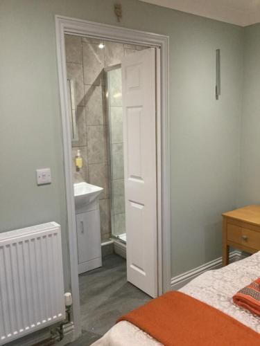 um quarto com um chuveiro e uma porta branca em The Hide at Pinchbeck em Spalding