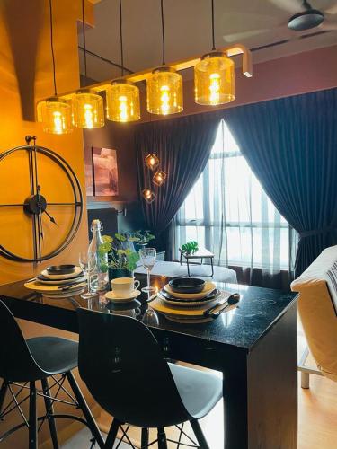 a dining room with a table with plates and chairs at Serene Studio Imperium Residence Kuantan in Kuantan
