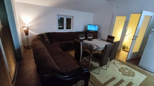 a living room with a couch and a table with a computer at Apartmani Mladenović in Kijevo