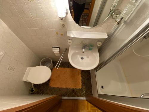 ein Badezimmer mit einem Waschbecken, einem Spiegel und einer Badewanne in der Unterkunft Hotel Flora in Bad Wörishofen