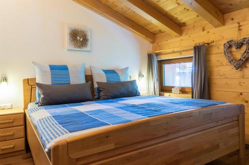 a bedroom with a large bed in a log cabin at Starmacher Hof in Itter
