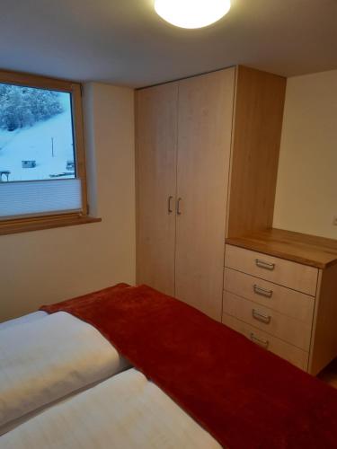 a small bedroom with a bed and a window at Ferienwohnung Schrofamühli in Silbertal