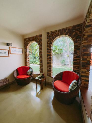two chairs in a living room with two windows at Urban Bliss Studio in Colombo